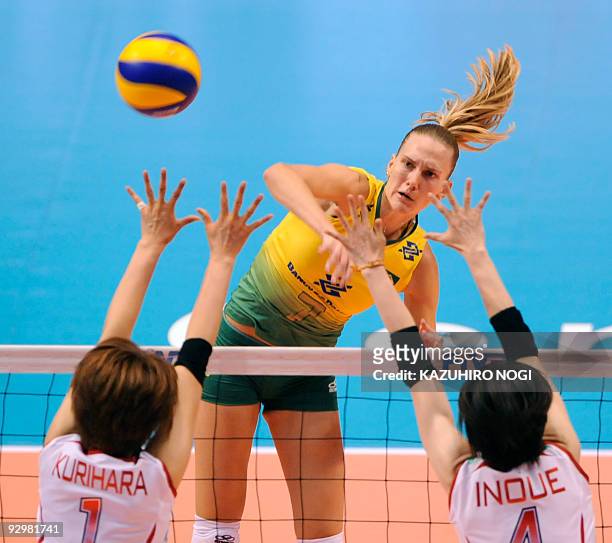 Brazil's Marianne Steinbrecher spikes the ball over Japan's Megumi Kurihara and Kaori Inoue during the women's World Grand Champions Cup at Tokyo...