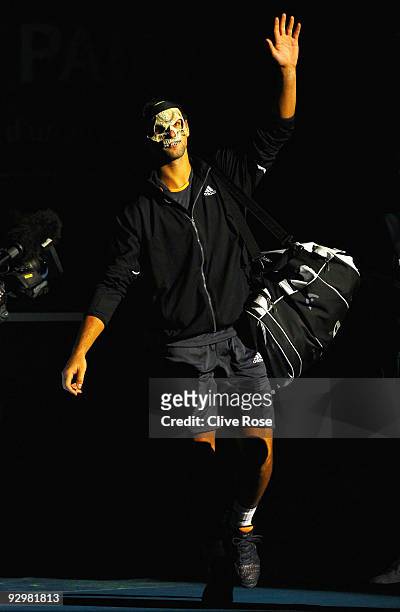 Novak Djokovic of Serbia enters the court wearing a mask during his match against Juan Monaco of Spain during the ATP Masters Series at the Palais...