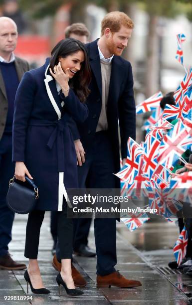 Meghan Markle and Prince Harry meet children during a walkabout at Millennium Point before attending an event to celebrate International Women's Day...