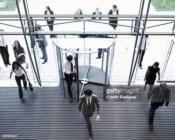 group of business people entering a building - bürogebäude stock-fotos und bilder