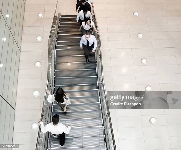 business people walking up and down stairs - descente stock pictures, royalty-free photos & images