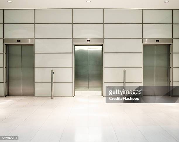 three lifts in office building - elevator doors stock-fotos und bilder