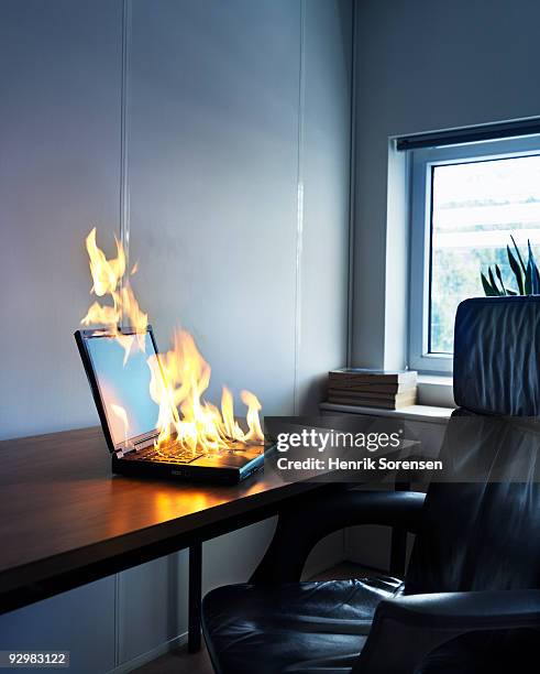 laptop on fire at desk in office - seat perilous fotografías e imágenes de stock