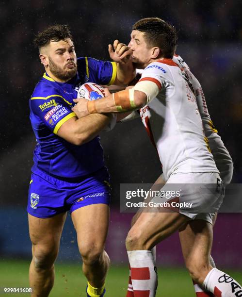 Joe Philbin of Warrington is tackled by Louie McCarthy-Scarsbrook of St Helens during the Betfred Super League between Warrington Wolves and St...