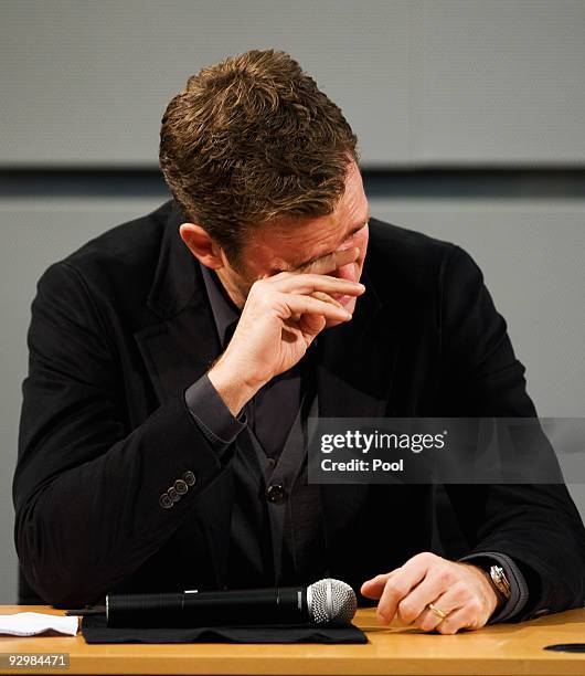 Manager Oliver Bierhoff wipes away his tears during the press conference of the German national football team due to the death of Robert Enke at the...