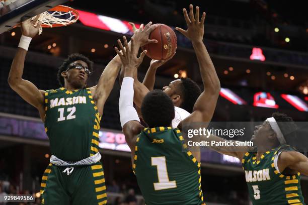 Chris Clover of the Saint Joseph's Hawks has his shot blocked by AJ Wilson of the George Mason Patriots during the first half in the Quarterfinals of...