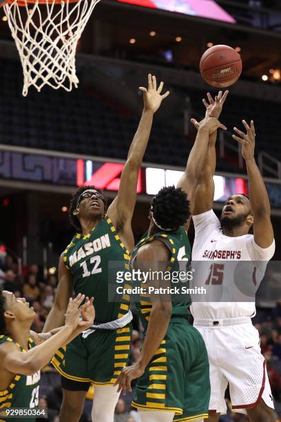 Chris Clover of the Saint Joseph's Hawks shoots in front of AJ Wilson of the George Mason Patriots during the first half in the Quarterfinals of the...