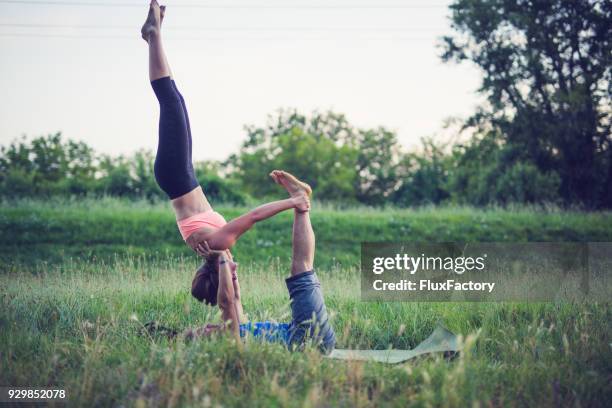 Two athletes performing duo acroyoga poses Stock Photo by Photology75