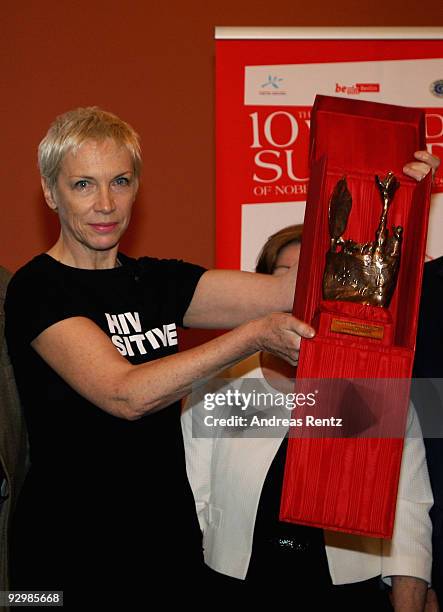 Musician Annie Lennox holds up the Peace award on the second day of the 10th World Summit of Nobel Peace Laureates at Berlin town hall on November...