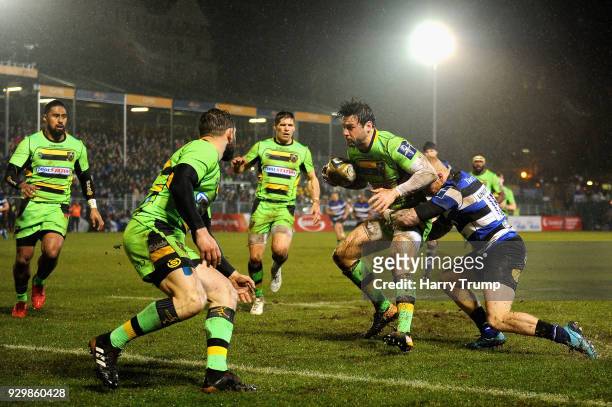 Ben Foden of Northampton Saints is tackled by Tom Homer of Bath during the Anglo-Welsh Cup Semi Final match between Bath and Northampton Saints at...