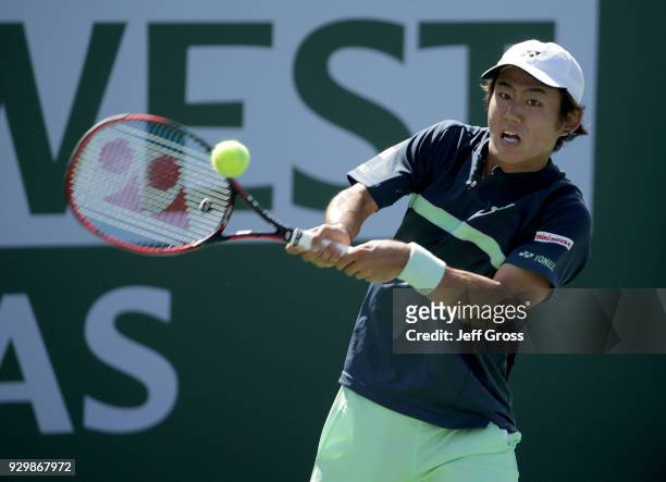 Yoshihito Nishioka of Japan returns a backhand to Marcos Baghdatis of Cyprus during the BNP Paribas Open at the Indian Wells Tennis Garden on March...