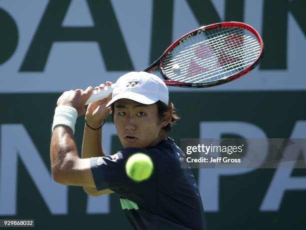 Yoshihito Nishioka of Japan returns a backhand to Marcos Baghdatis of Cyprus during the BNP Paribas Open at the Indian Wells Tennis Garden on March...