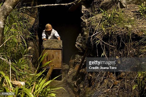 Miner pushes a cart with dirt to be washed by his co-workers in the San Francisco mines on February 24, 2009 in San Francisco, Boyaca,...