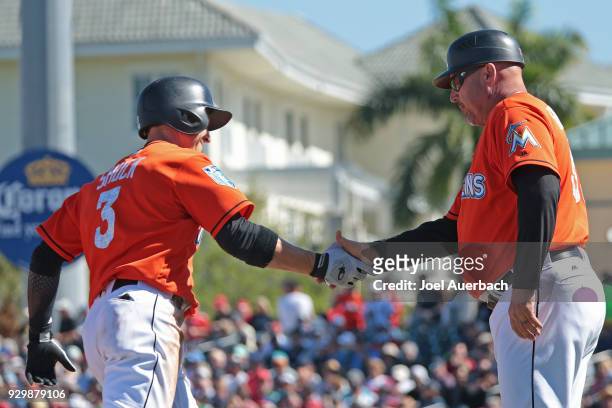 Third base coach Fredi Gonzalez congratulates J.B. Shuck of the Miami Marlins as he rounds third base after hitting a home run in the sixth inning...