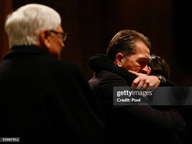 Andreas Koepke, goalkeeper trainer of German national team, embraces Teresa Enke , widow of goalkeeper Robert Enke, beside President of the German...