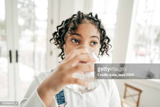 belang om gehydrateerd worden - african girl drinking water stockfoto's en -beelden