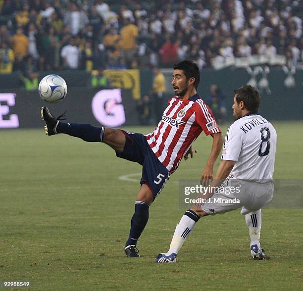 Paulo Nagamura of Chivas USA kicks the ball away from midfielder Dema Kovalenko of the Los Angeles Galaxy during the Playoff Super Clásico match at...