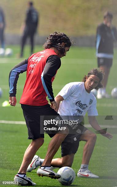 Uruguay's Sebastian Abreu tries to get away from his teammate Alvaro Gonzalez during a training at the Proyecto Gol in Guatemala city on November 11,...