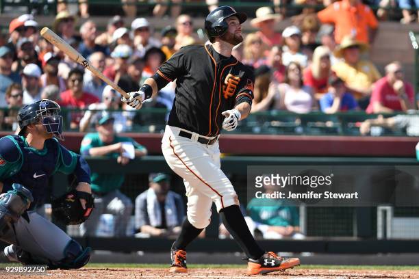 Brandon Belt of the San Francisco Giants hits a two run home run in the second inning of the spring training game against the Seattle Mariners at...