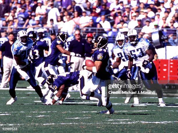 Wide Receiver Jermaine Lewis of the Baltimore Ravens carries the ball pursued by Line Backer Keith Bulluck and Safety Perry Phenix of the Tennessee...