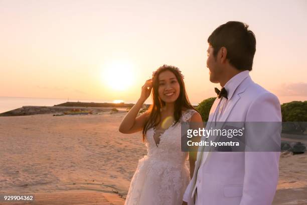 wedding at the sunset beach - sunset beach bouquet wedding couple stock pictures, royalty-free photos & images