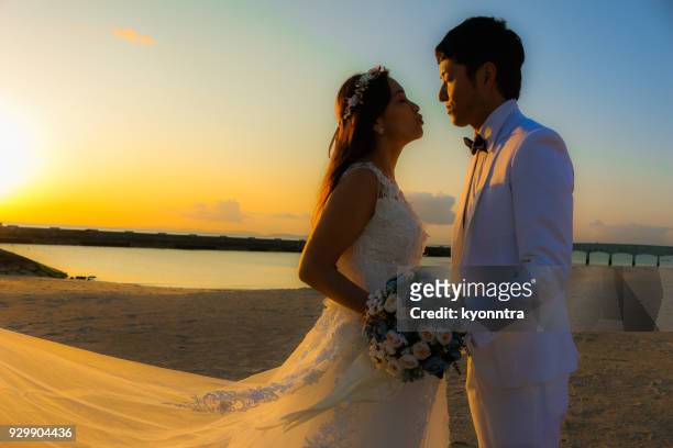 wedding at the sunset beach - sunset beach bouquet wedding couple stock pictures, royalty-free photos & images