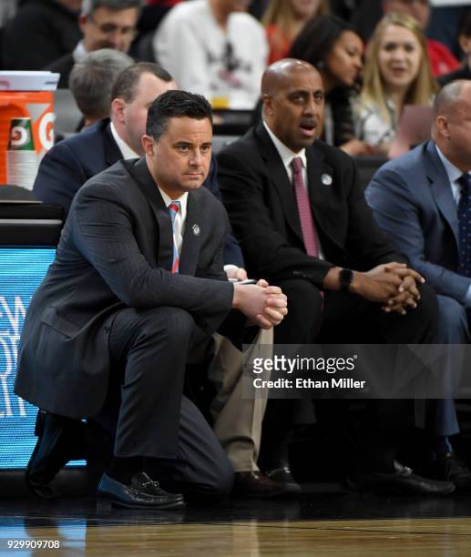 Head coach Sean Miller and associate head coach Lorenzo Romar of the Arizona Wildcats look on during a quarterfinal game of the Pac-12 basketball...