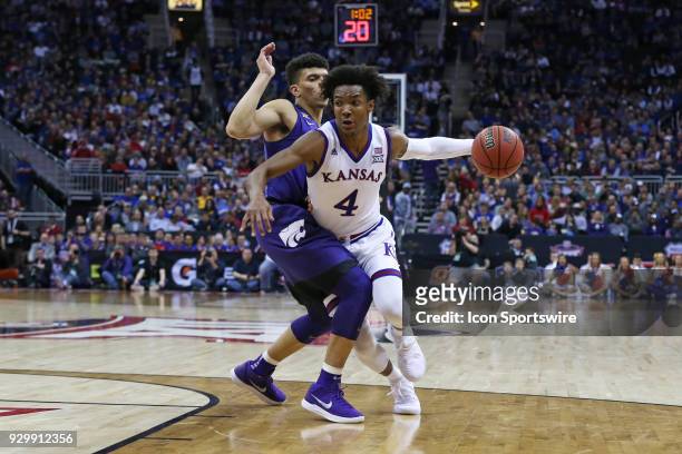 Kansas Jayhawks guard Devonte' Graham tries to get past Kansas State Wildcats guard Mike McGuirl in the first half of a semifinal game in the Big 12...
