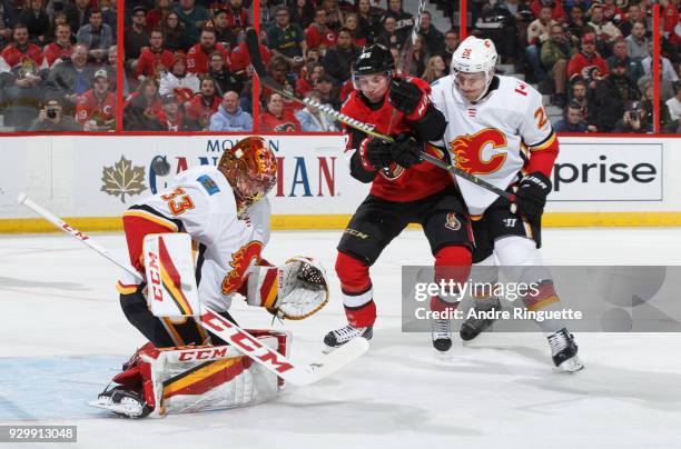 David Rittich of the Calgary Flames makes a save as Matt Duchene of the Ottawa Senators drives to the net for a rebound against Michael Stone at...