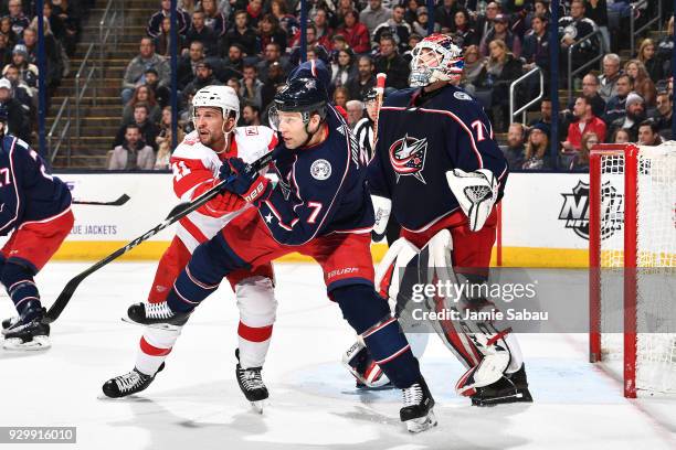 Luke Glendening of the Detroit Red Wings and Jack Johnson of the Columbus Blue Jackets battle for position in front of goaltender Sergei Bobrovsky of...