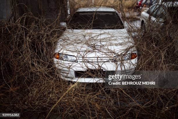 This picture taken on March 5, 2018 shows an abandoned car at a car store in Okuma town, Fukushima prefecture, as Japan prepares to mark the 7th...