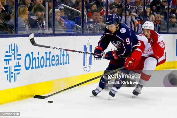 Artemi Panarin of the Columbus Blue Jackets and Danny DeKeyser of the Detroit Red Wings chase after the puck during the second period on March 9,...