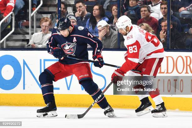 Jack Johnson of the Columbus Blue Jackets plays the puck with his skate as Trevor Daley of the Detroit Red Wings defends during the third period of a...