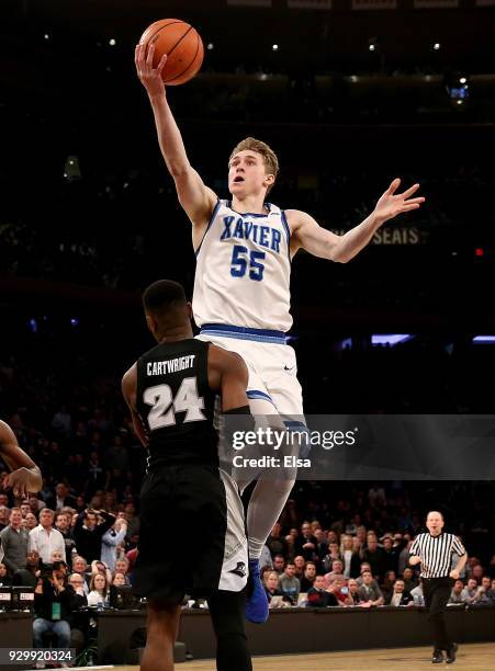 Macura of the Xavier Musketeers heads for the net as Kyron Cartwright of the Providence Friars defends in the final minute of the overtime period...