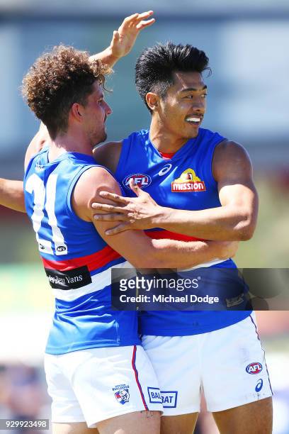 Tom Liberatore and Lin Jong of the Bulldogs celebrates a goal during the JLT Community Series AFL match between Collingwood Magpies and the Western...