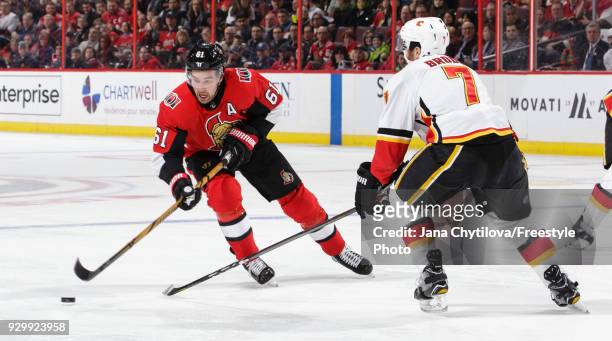 Mark Stone of the Ottawa Senators skates with the puck against TJ Brodie of the Calgary Flames in the second period at Canadian Tire Centre on March...