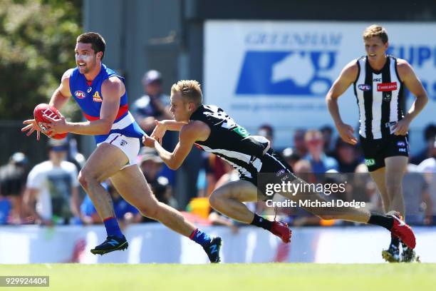 Bailey Williams of Footscray is tackled by Jaidyn Stephenson of the Magpies during the JLT Community Series AFL match between Collingwood Magpies and...