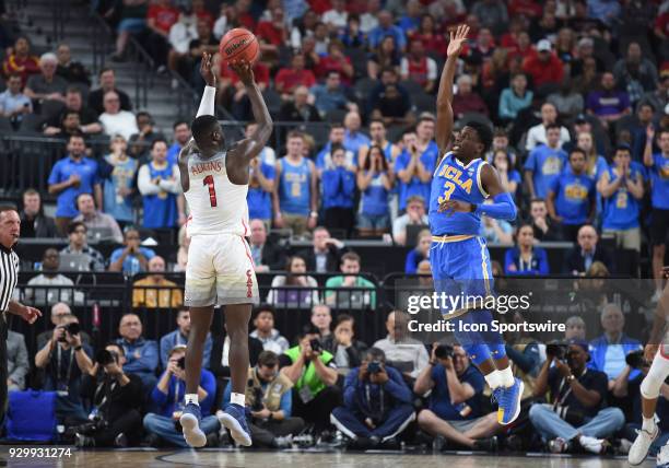 Guard Aaron Holiday attempts to block a shot by Arizona guard Rawle Alkins during the PAC-12 Men's Basketball Tournament semifinal game between the...