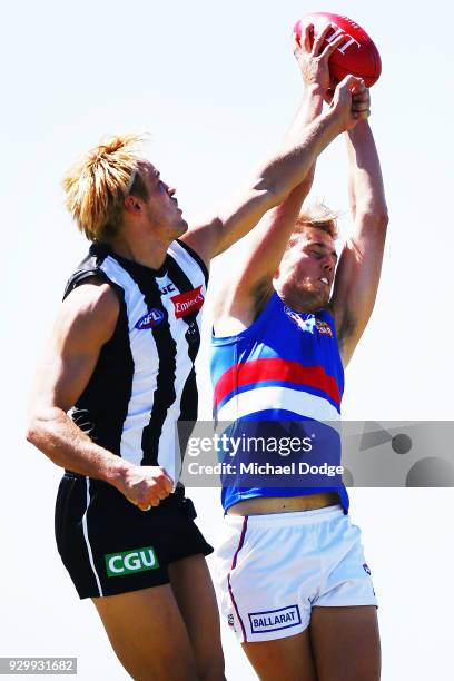 Josh Schache of the Bulldogs marks the ball against Darcy Moore during the JLT Community Series AFL match between Collingwood Magpies and the Western...