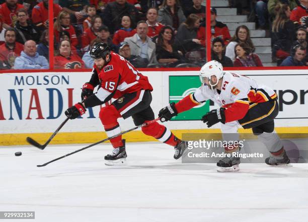 Zack Smith of the Ottawa Senators shoots the puck on a backhand against Mark Giordano of the Calgary Flames at Canadian Tire Centre on March 9, 2018...