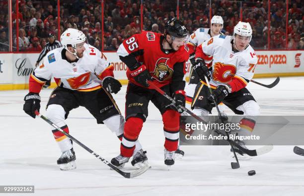 Matt Duchene of the Ottawa Senators controls the puck against TJ Brodie and Micheal Ferland of the Calgary Flames at Canadian Tire Centre on March 9,...