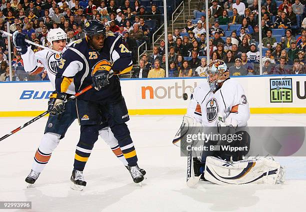 Michael Grier of the Buffalo Sabres is stopped by Steve Staios and goalie Nikolai Khabibulin of the Edmonton Oilers on November 11, 2009 at HSBC...