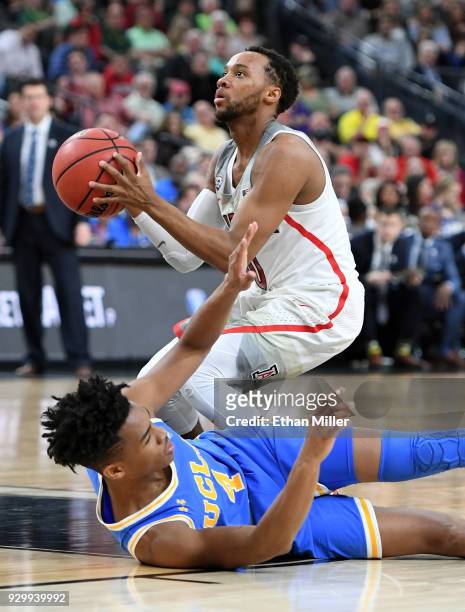 Parker Jackson-Cartwright of the Arizona Wildcats is fouled by Jaylen Hands of the UCLA Bruins during a semifinal game of the Pac-12 basketball...