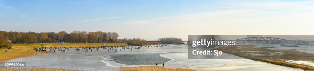People ice skating on a frozen lake next to the river IJssel near Zwolle