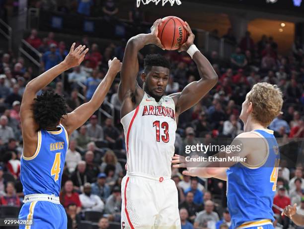 Deandre Ayton of the Arizona Wildcats grabs a rebound against Jaylen Hands and Thomas Welsh of the UCLA Bruins during a semifinal game of the Pac-12...