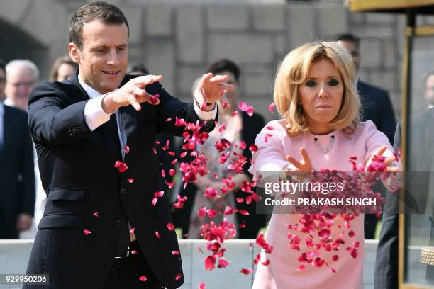 France's President Emmanuel Macron and his wife Brigitte Macron offer tributes at Rajghat memorial for Mahatma Gandhi in New Delhi on March 10, 2018....