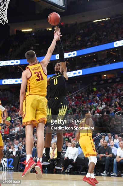 Oregon forward Troy Brown attempts to shoot over USC forward Nick Rakocevic during the PAC-12 Men's Basketball Tournament semifinal game between the...
