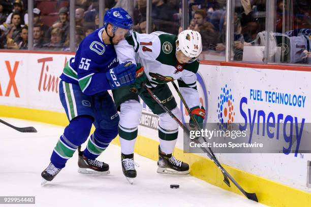 Minnesota Wild Center Joel Eriksson Ek is checked by Vancouver Canucks Defenceman Alex Biega during their NHL game at Rogers Arena on March 9, 2018...