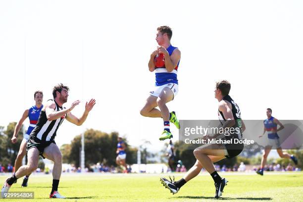 Lachie Hunter of the Bulldogs gathers the ball during the JLT Community Series AFL match between Collingwood Magpies and the Western Bulldogs at Ted...