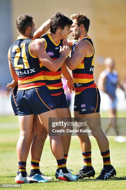 Darcy Fogarty of the Crows celebrates with his team mates after kicking a goal during the JLT Community Series AFL match between Port Adelaide Power...